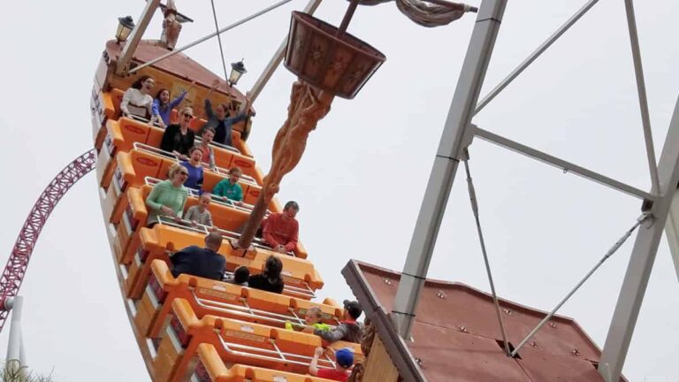 People scream while swinging backward on a pirate ship amusement park ride