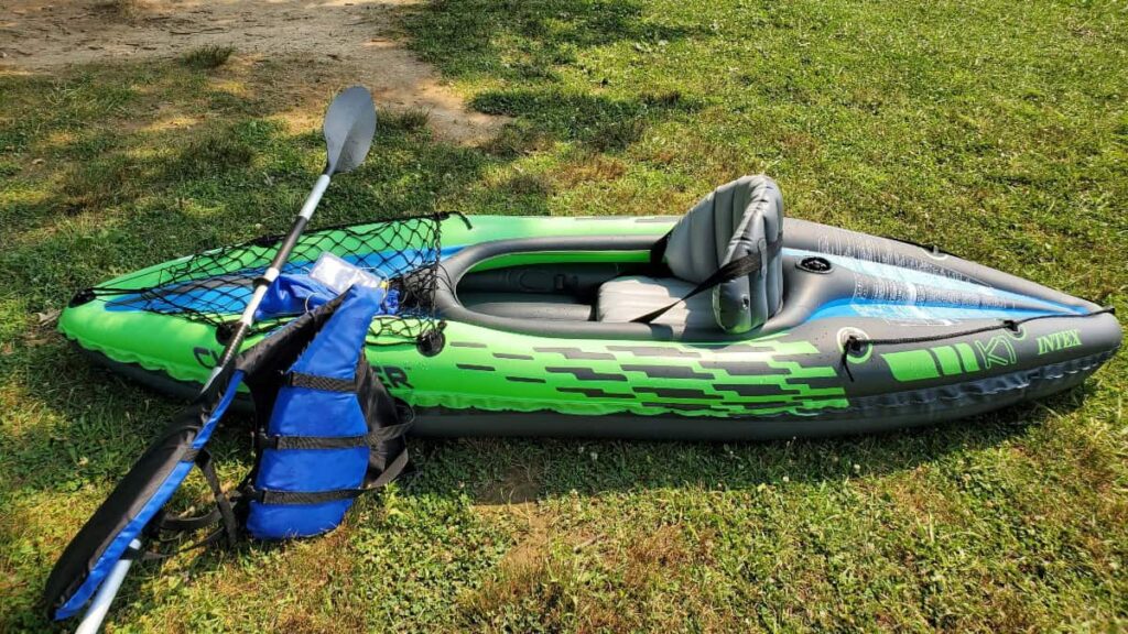 looking down at an inflatable kayak as it sits on the grass waiting to launch