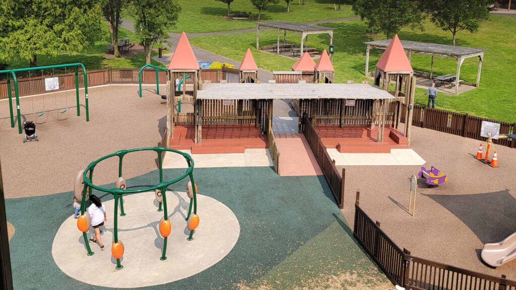 View of the entrance, seating, and play structures looking down from Kids Castle