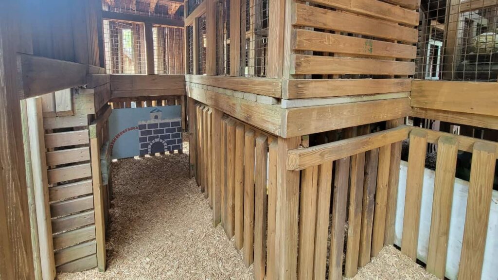 Looking inside the Kids Castle playground in Doylestown, the ground level is covered in wood mulch chips