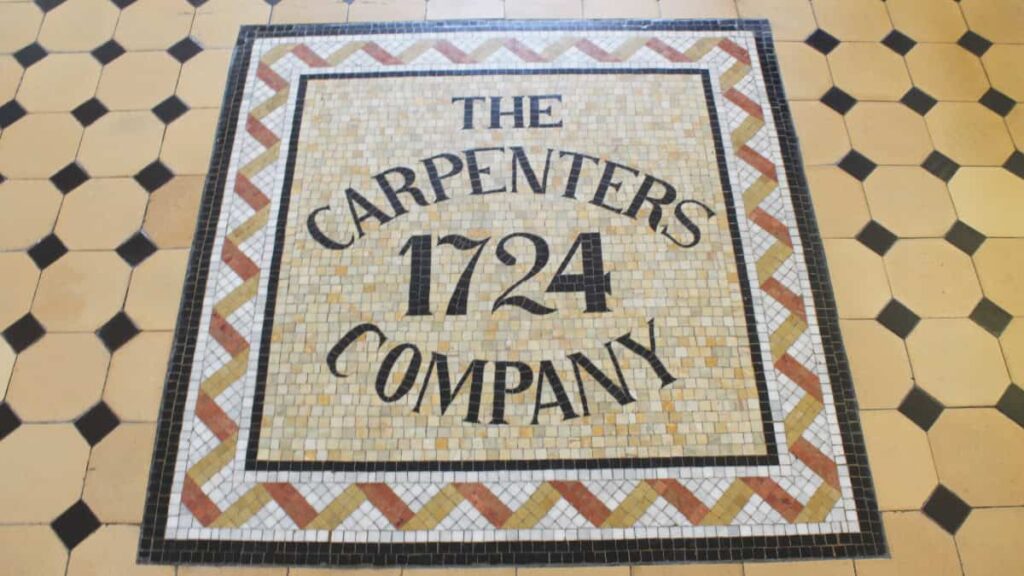 A tile sign laid in the floor reads The Carpenters Company 1724