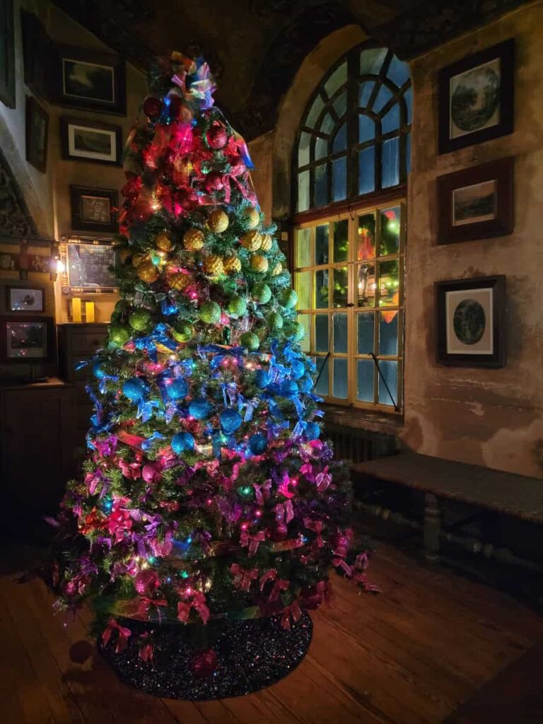 A Christmas tree is decorated in ornaments that make it look like a rainbow inside Fonthill castle