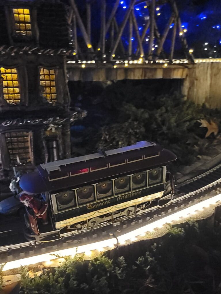 A close up of a model trolley train at night