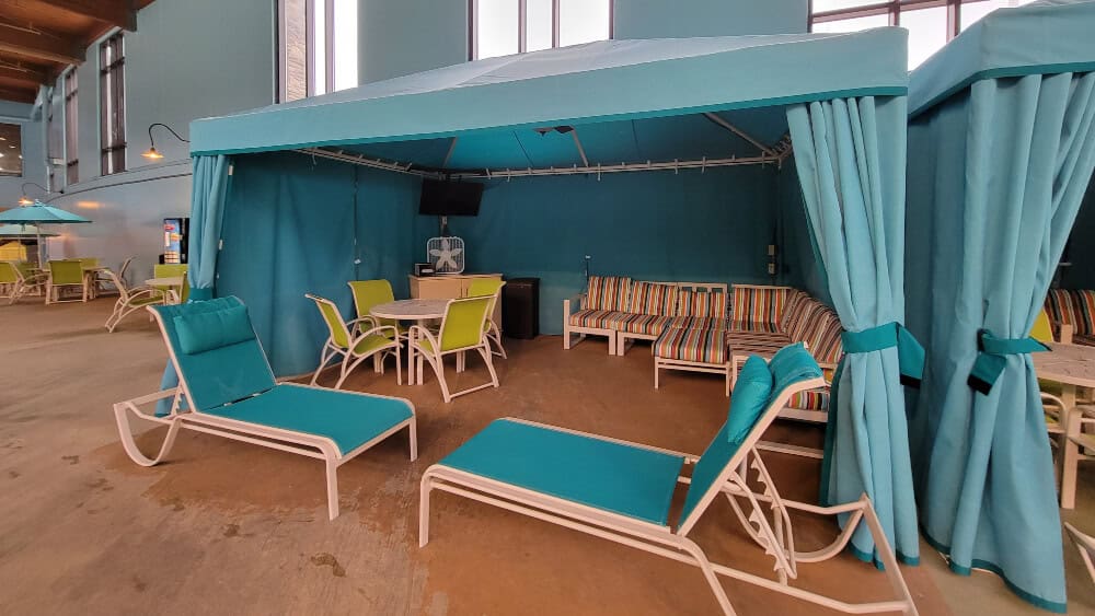 Looking at a cabana with two lounge chairs and a table and chairs inside Camelback Aquatopia
