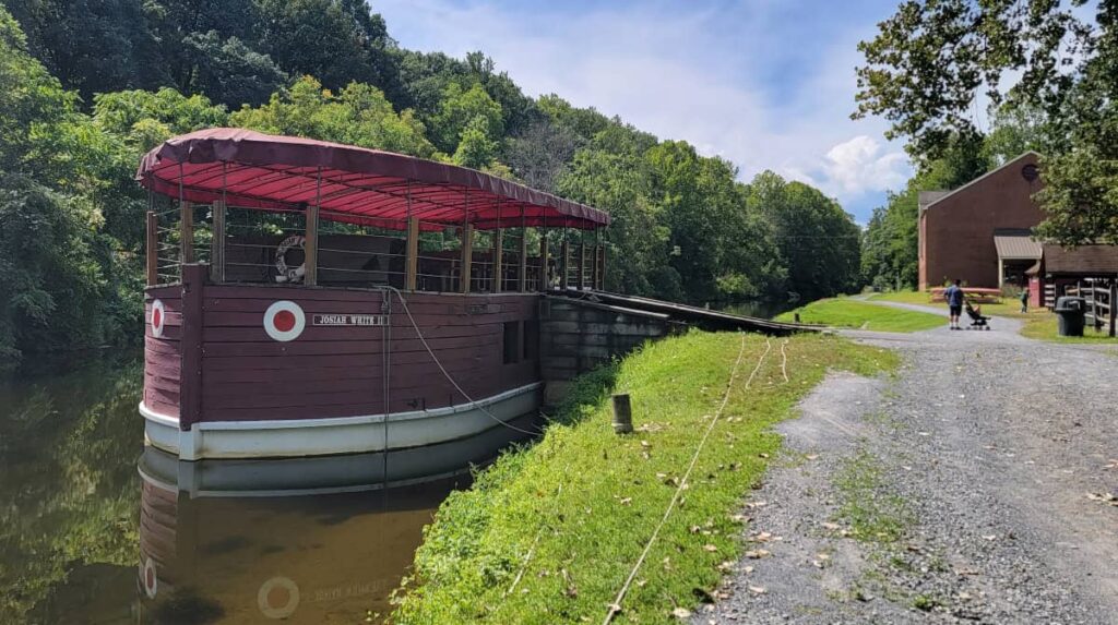 A canal boat sits docked with the towpath on the rights