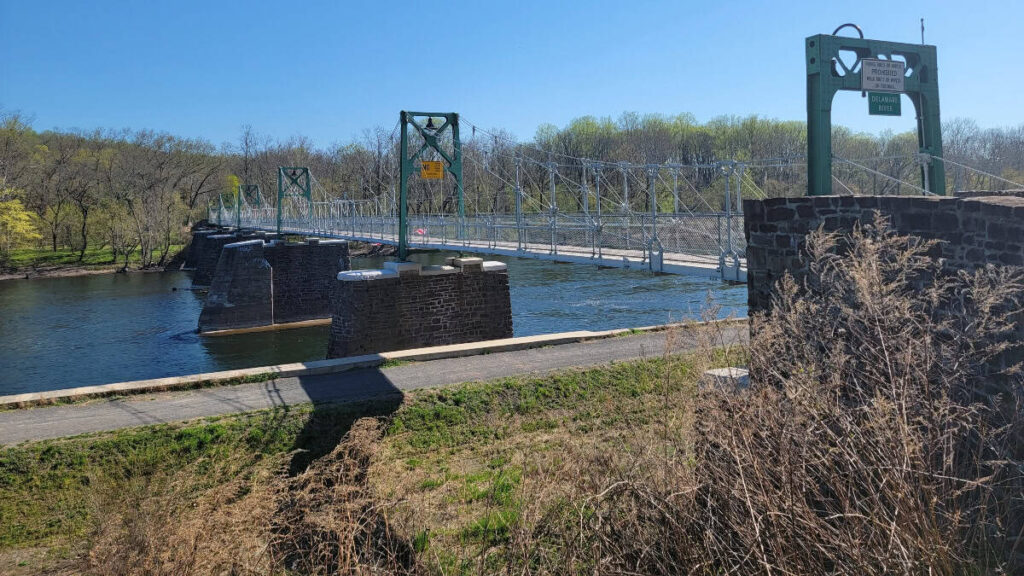 A concrete and metal footbridge crosses the Delaware River from Lumberville to Bulls Island